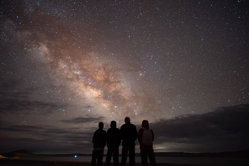 Viajeros contemplando en silencio el cielo nocturno del Valle del Elqui.